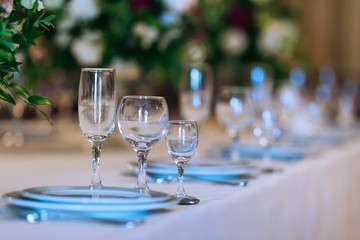 close-up of transparent glasses of different shapes on a table with a white tablecloth
