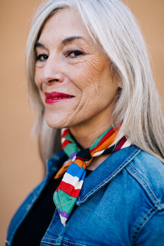 Portrait of a cool senior woman with grey long hair wearing denim clothes.