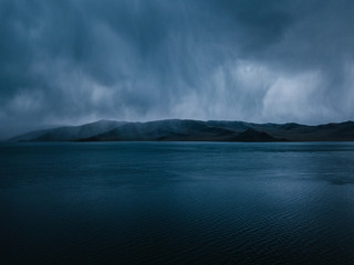 storm clouds above tolbo nuur lake with a mountain range in mongolia