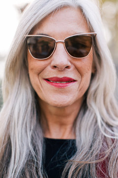 Closeup portrait of a mature woman with grey hair   wearing sunglasses.