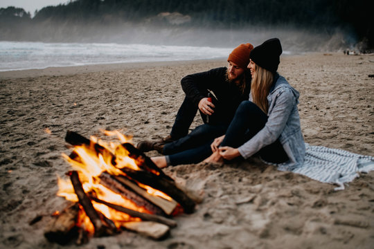 couple enjoying campfire at the beach