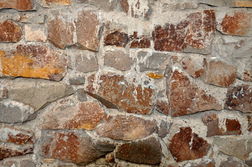stone wall still under construction, mortar joints to be completed and stones need a final cleaning.