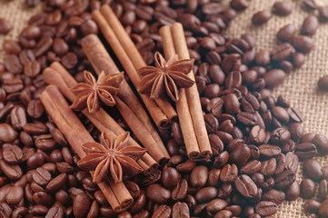 Aromatic roasted coffee beans and anis or badian, sticks of natural cinnamon on  background close up