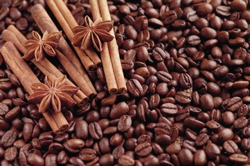 Aromatic roasted coffee beans and anis or badian, sticks of natural cinnamon on  background close up