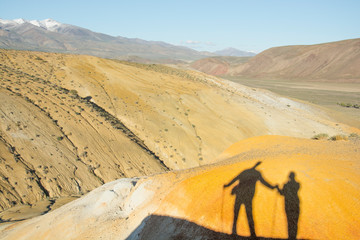 Fototapeta na wymiar Shadow of couple on hill. Mars mountains, the name of colored mountain protrusions in the mountains of Kyzyl-Chin. Altai, Russia. A delightful landscape of unreal beauty.