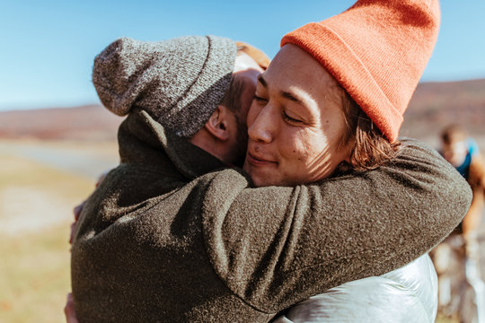 Friends hugging on an airfield after flying glider planes
