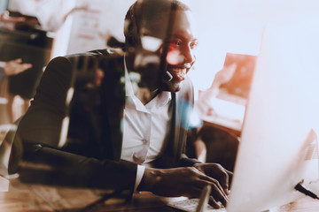 Sitting Afro-American Man Working in Call Center.