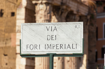 Imperial Fora Avenue old marble road sign with ancient ruins background in Rome