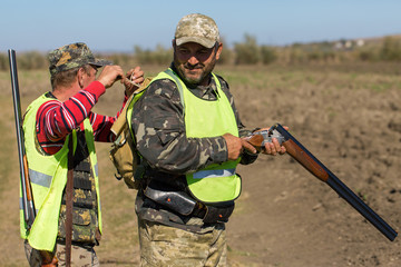 Hunters with a german drathaar and spaniel, pigeon hunting with dogs in reflective vests	