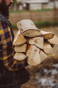 man carries wood pieces