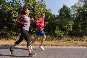 Obraz premium young couple jogging along a country road