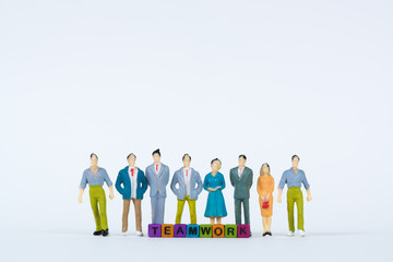 TEAMWORK text and Group of figure miniature businessman or small people investor and office worker secretary on white background for money and financial business teamwork concept.