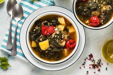 vegan winter kale soup with buckwheat , cherry tomatoes and potatoes. tasty full vegetable food for the whole family