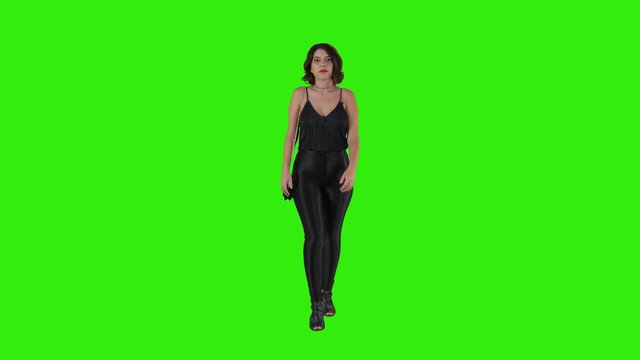 Pretty woman walking for a date night over a green screen in a full frontal shot.