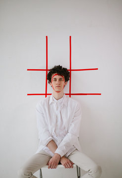 Young man posing with red sticky tape on his face