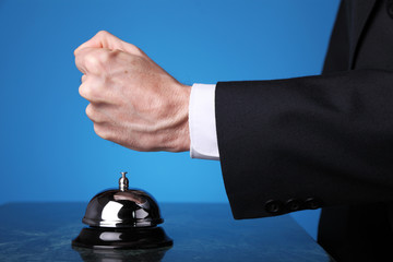 Angry customer ringing reception bell in hotel