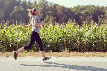 woman jogging along a country road