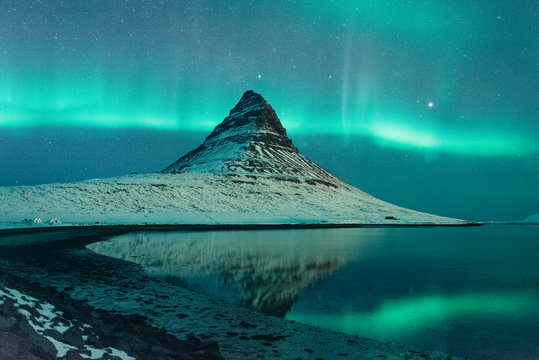 Northern lights over snowy mountain peak