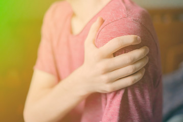 close up hand touching shoulder, feeling bone pain f