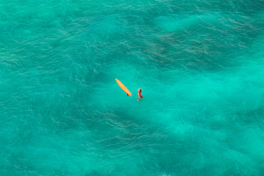 Woman surfing at wild tropical beach