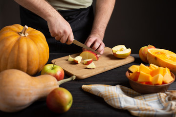The cook cuts the apple into pieces for baking.