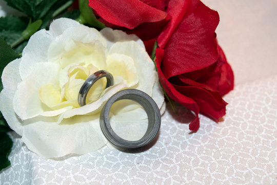 The bride and groom chose Damascus wedding bands and red and yellow silk flowers.