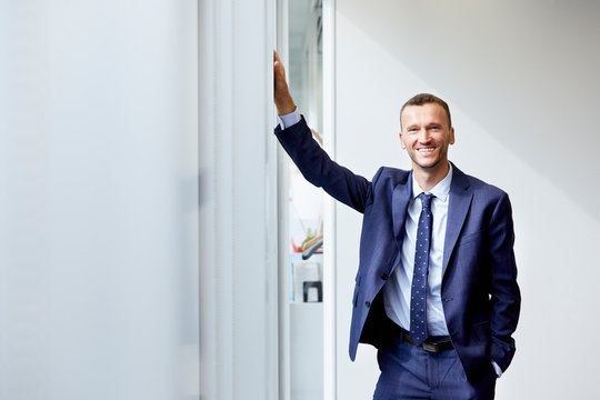 Portrait Of Smiling Businessman Standing In Office