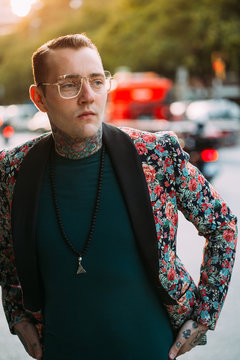 Tattooed handsome man with colourful flower jacket around the city.