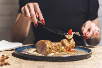Woman eating rolled meat at restaurant