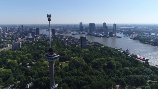 Aerial bird view flight past Euromast popular tourist attraction in Rotterdam the second largest city in Netherlands in South Holland heading towards Erasmusbridge and Noordereiland in background 4k