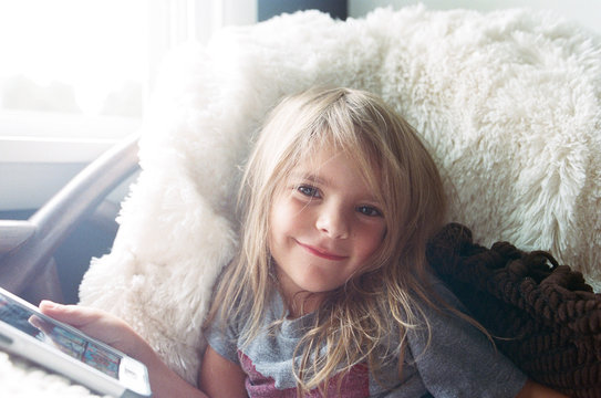 Child looking at phone in cozy chair