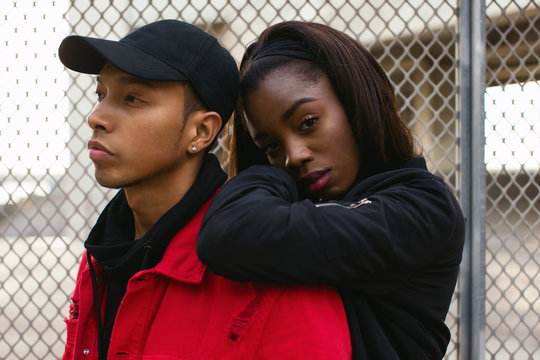 Portrait of cool multiethnic couple standing on the street.