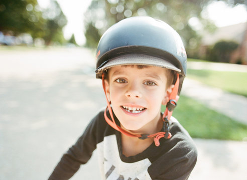 Boy smiling with missing tooth and bike helmet