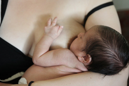 Young mother nurses her newborn