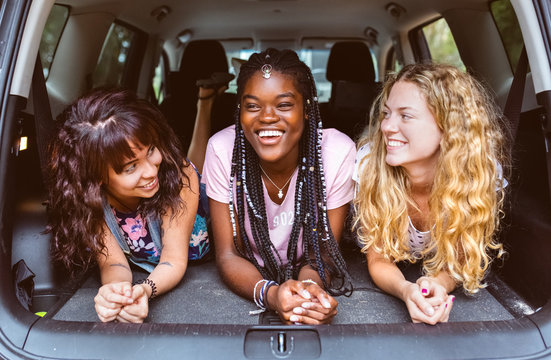 Three young friends having fun in a car