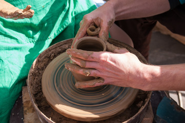 Pottery training, four hands make a pot of clay