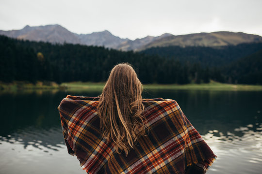 Young woman enjoying at lake on autumn day.
