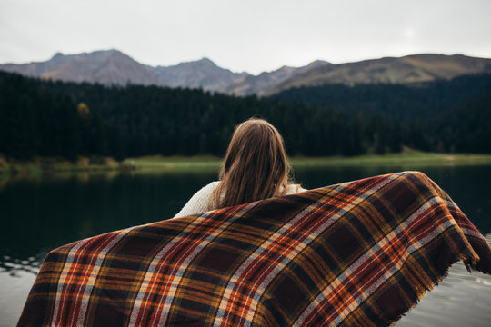 Young woman enjoying at lake on autumn day.