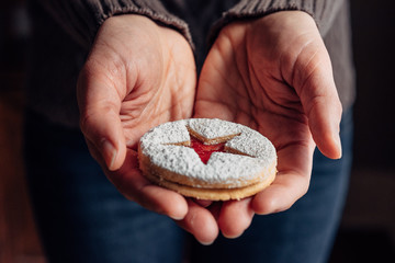 Close up of a Linzer Christmas cookie in a woman's hands