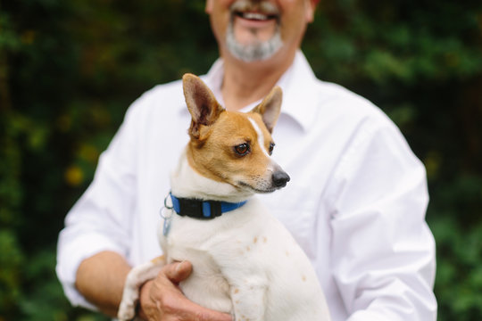 Happy, Elderly Man Holding Small Dog