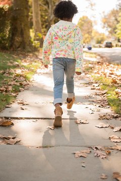 Girl walking on sidewalk