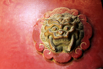 beast sculpture on red wooden door in a temple