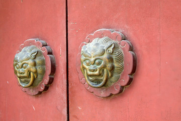 beast sculpture on red wooden door in a temple