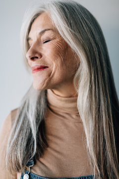 Portrait of a smiling senior woman with grey long hair.