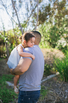 Young dad playing with child outside in suburb neighborhood