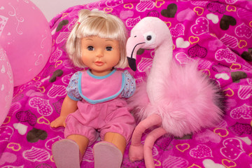 Children's toys, baby doll and pink flamingo, gifts for children. Holiday with balloons.