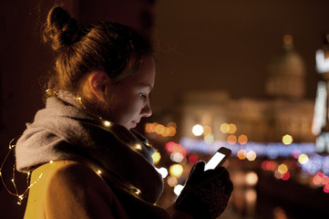 Young woman using phone at night