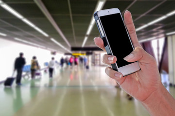 Man using smartphone at airport and blurry background with clipping path on screen panel