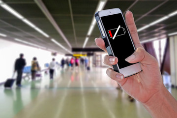 Man using LOW BAT smartphone at airport and blurry background with clipping path on screen panel