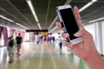 Man using smartphone at airport and blurry background with clipping path on screen panel